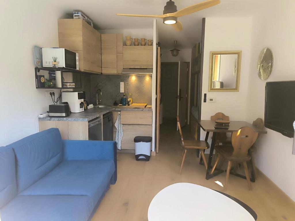 a living room with a blue couch and a table at Studio à Vallouise-Pelvoux - Puy Saint Vincent, nature, rando et ski in Vallouise