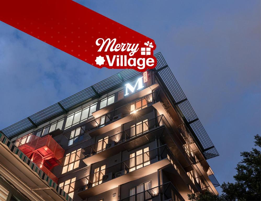 a building with a sign on the side of it at M Village Hotel Hai Bà Trưng in Ho Chi Minh City