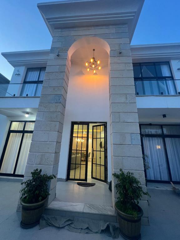 Lege Tʼafovilla Rosetta的两棵盆栽植物的建筑物的前门