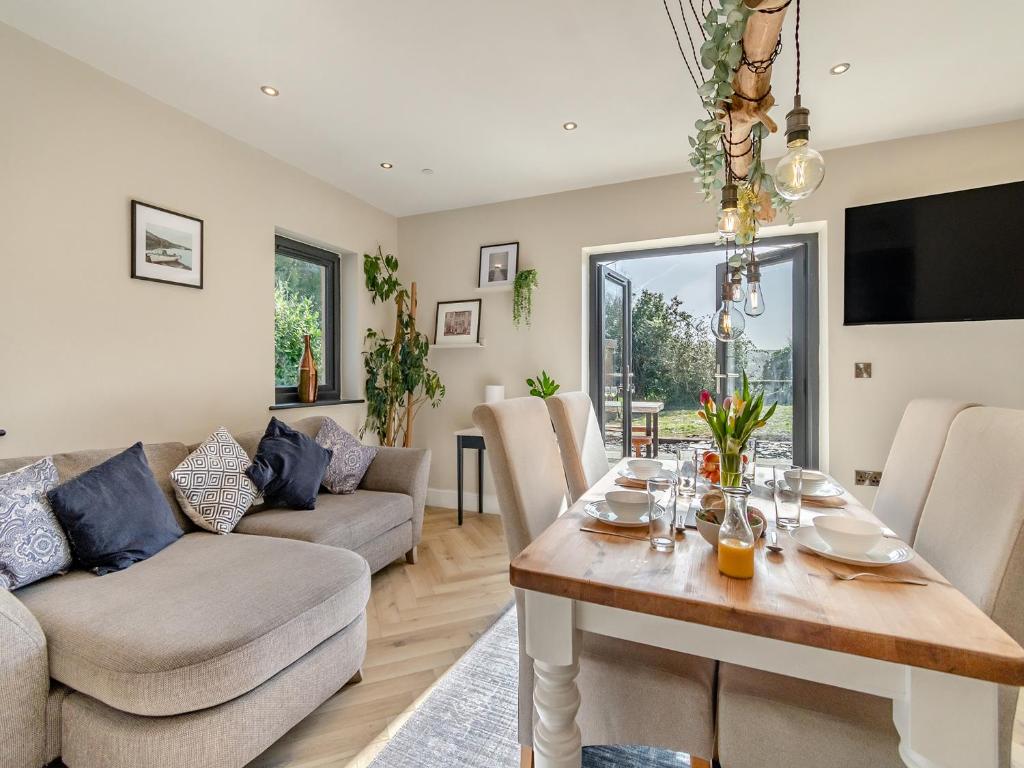 a living room with a table and a couch at Bwythyn Cudd in Manortown
