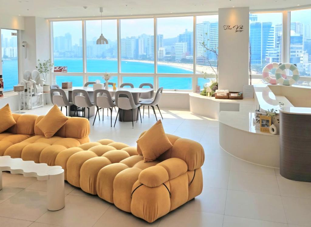 a living room with a couch and a table and chairs at TheVibe Gwangan-Grand Oceanview Private Villa in Kwangan-dong
