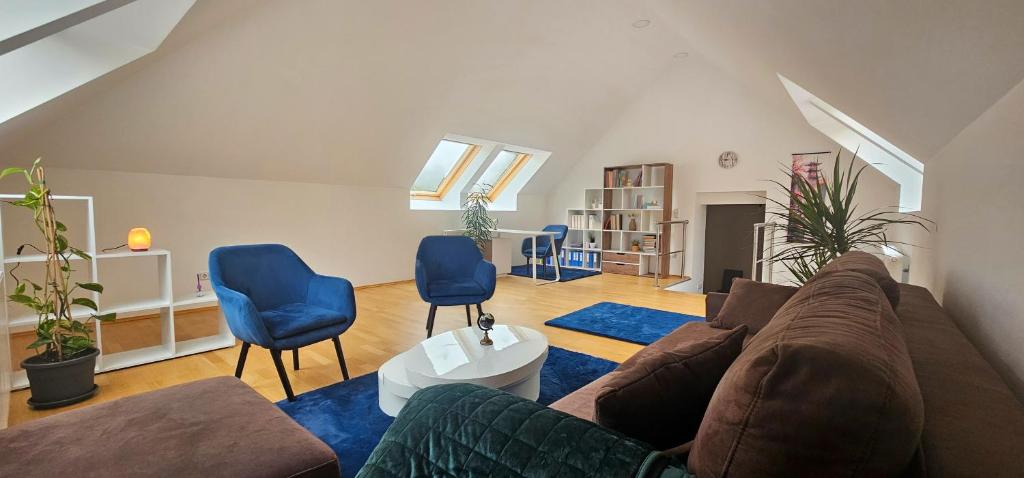 sala de estar con sofá y 2 sillas azules en Loft Klagenfurt, en Klagenfurt