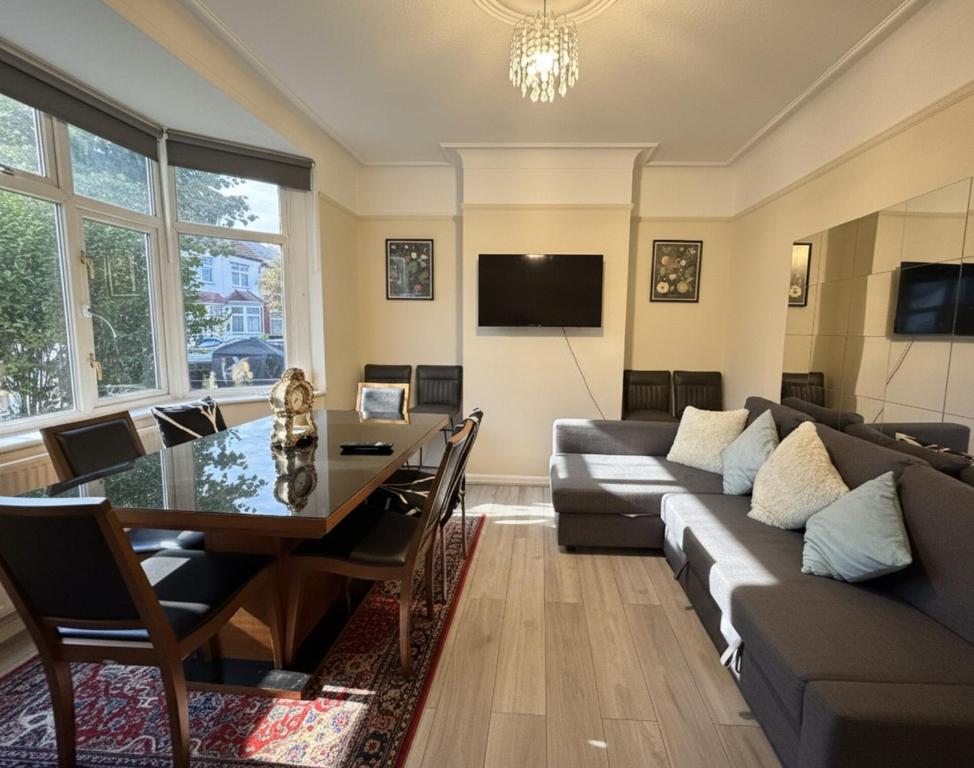 una sala de estar con un sofá y una mesa en East Ham House, en Londres