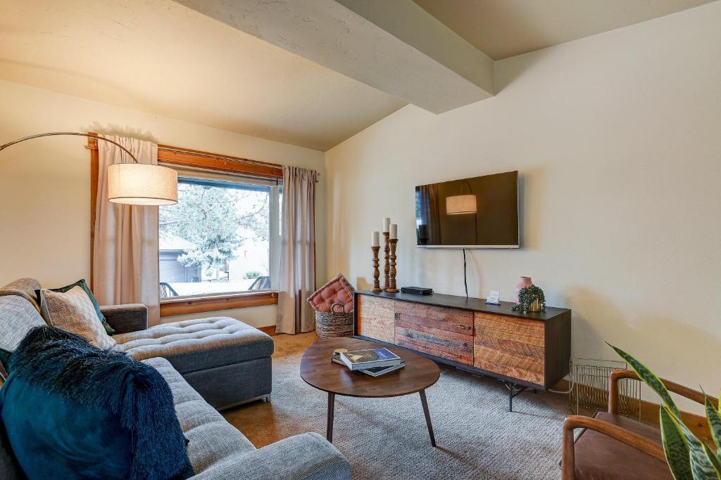 a living room with a couch and a tv at The Bend House in Bend