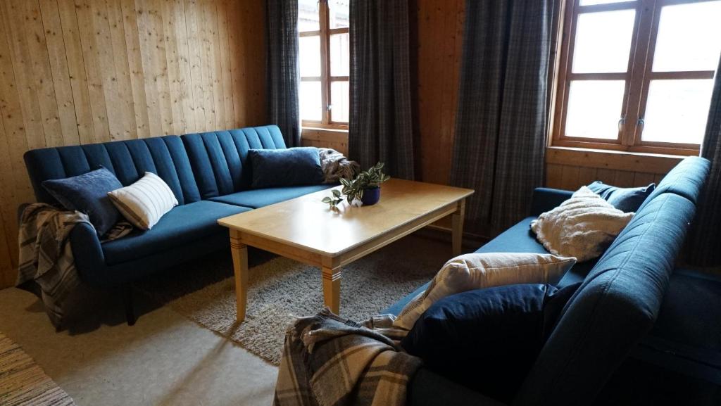 a living room with two blue couches and a coffee table at 31 - Idarbua, real fisherman's cabin in Lofoten in Ballstad