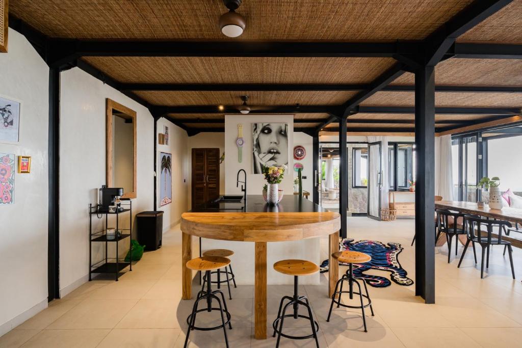 eine Küche mit einer Bar und einigen Hockern in der Unterkunft Mar de Uluwatu - Ocean View Villa in Uluwatu