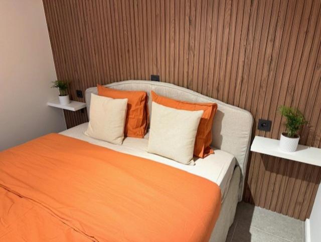 an orange and white bed with three pillows on it at Residentie Peter Pan in Knokke-Heist