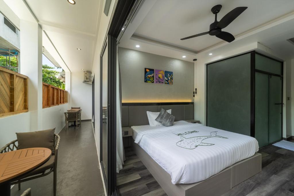 a bedroom with a large bed and a table at Kirulhiya Omadhoo - Live the Island Dream in Omadhoo
