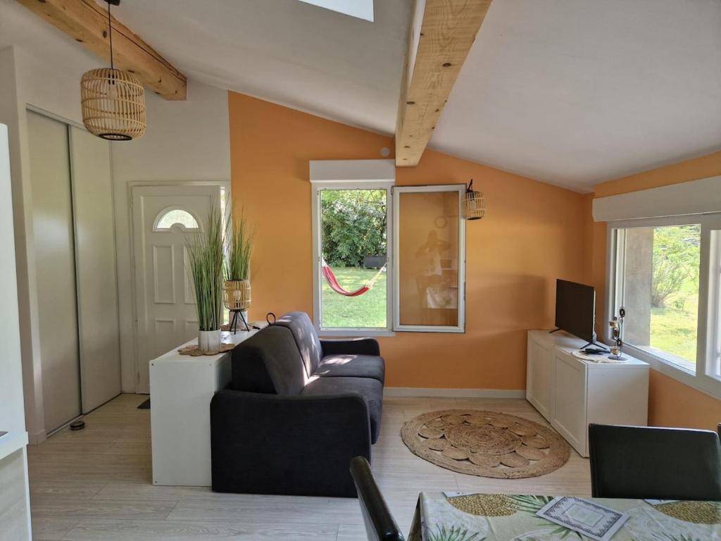 a living room with a couch and a tv at Cottage with large garden in Rieumajou