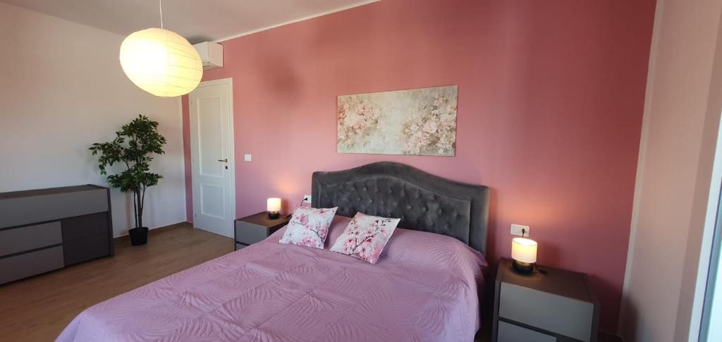a pink bedroom with a bed with pink sheets and pillows at Casa Tintoretto The Charm of Venice in 15 minutes! in Venice