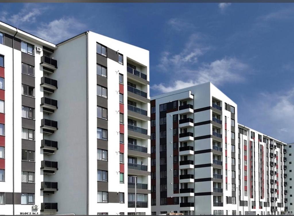 two tall white apartment buildings against a blue sky at RxM HOME CITY in Chiajna