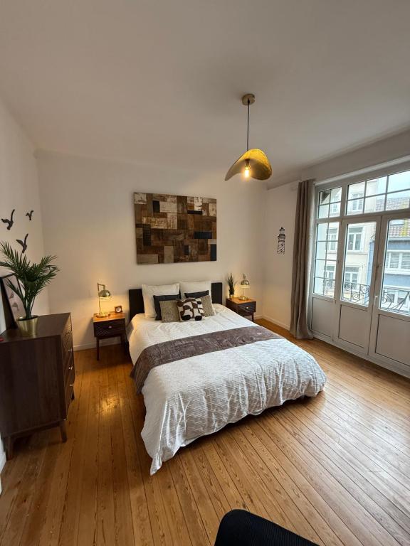 ein Schlafzimmer mit einem großen Bett und einem großen Fenster in der Unterkunft Chambre Le Phare - Villa Les Embruns - à 5min à pied de Nausicaa, plage, centre Ville - Côte d'Opale in Boulogne-sur-Mer