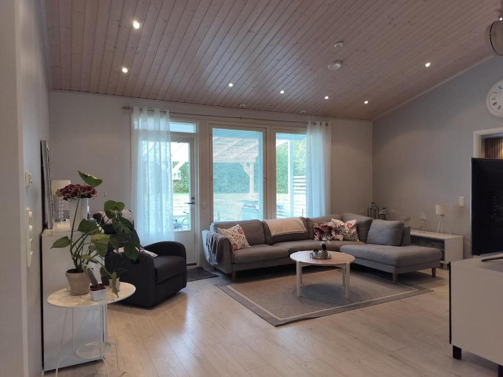 a living room with a couch and a tv at Cozy detached house near the city in Rovaniemi