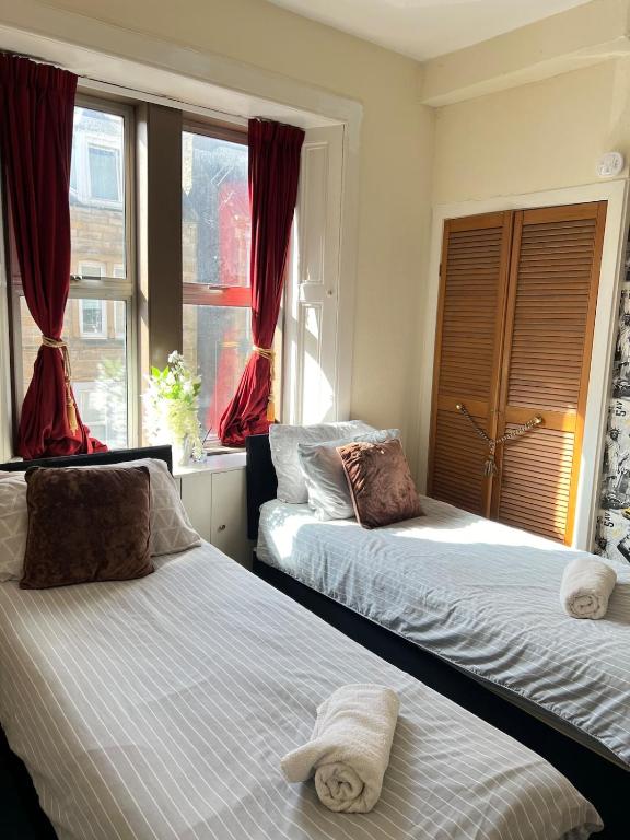 a bedroom with two beds and a window at 1st Class Central 4 Bedroom 2 Bathrooms in Galashiels