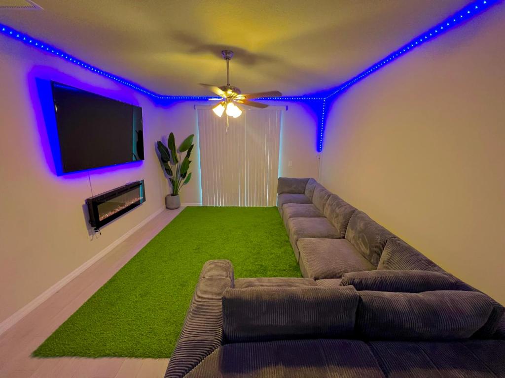 a living room with a couch and a tv at Entire Brand New Modern Lake House Family Fun in Auburndale