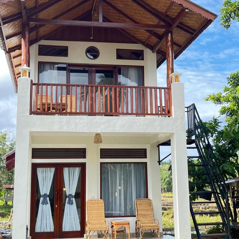 a small house with a balcony and a deck at Green Corner Villa in Bukit Lawang