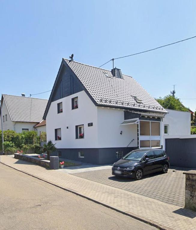 a black car parked in front of a white house at Adler Haus in Neunkirchen