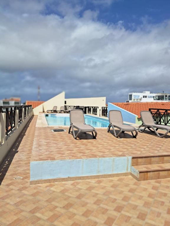 a patio with chairs and a pool on a roof at Patio Antigo 218 in Santa Maria