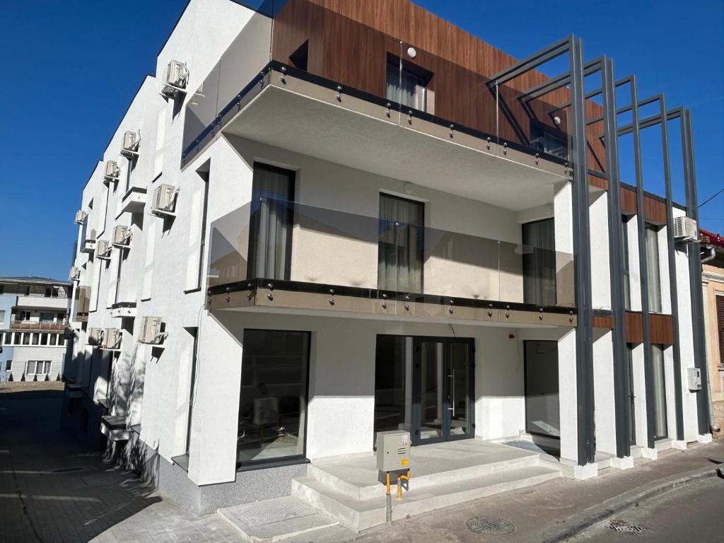a white building with a balcony on the side of it at Fit Residence Hasdeu in Cluj-Napoca