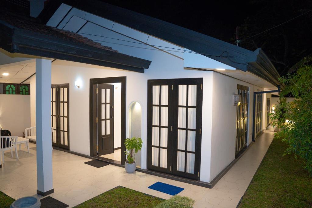 a white house with windows and doors at night at Cinnamon Wave Villa - Thalaramba, Mirissa in Matara