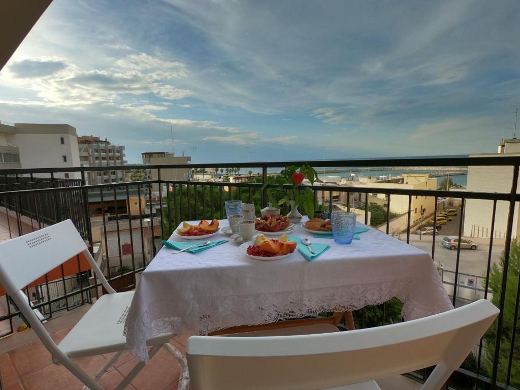 a table with food on top of a balcony at Sunset Home in Bari