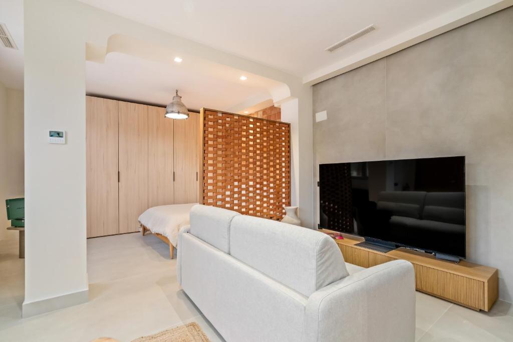un salon avec un canapé blanc et une télévision dans l'établissement 139 Boutique Stay, à Vallecas