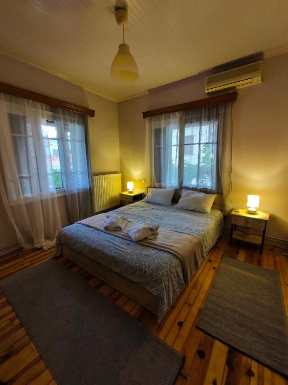 a bedroom with a bed with two lamps and two rugs at Citadel's Tranquility Ioannina in Ioannina
