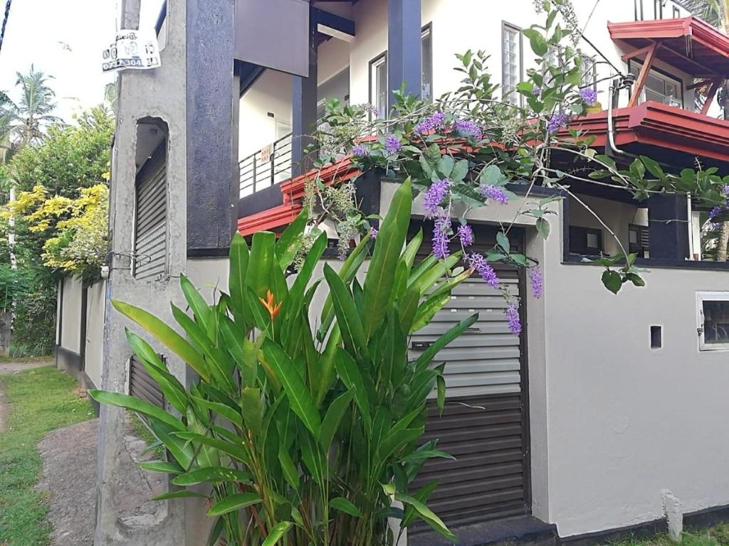 a house with flowers on the side of it at Menuks villa in Habaraduwa Central