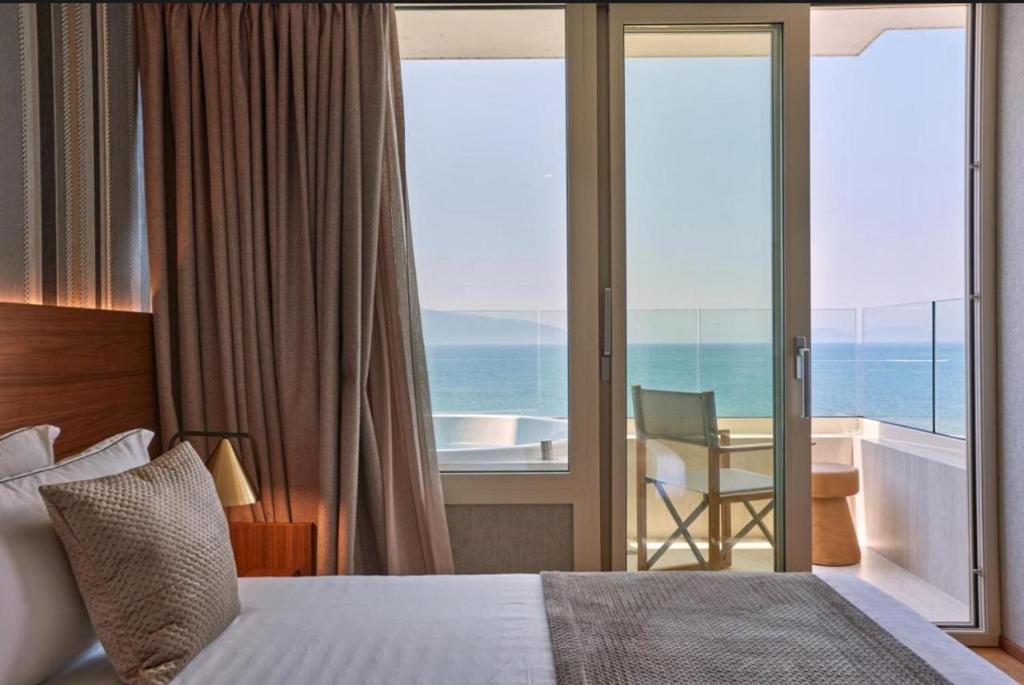 a bedroom with a bed and a view of the ocean at Shëngjin Shores Apartments in Shëngjin