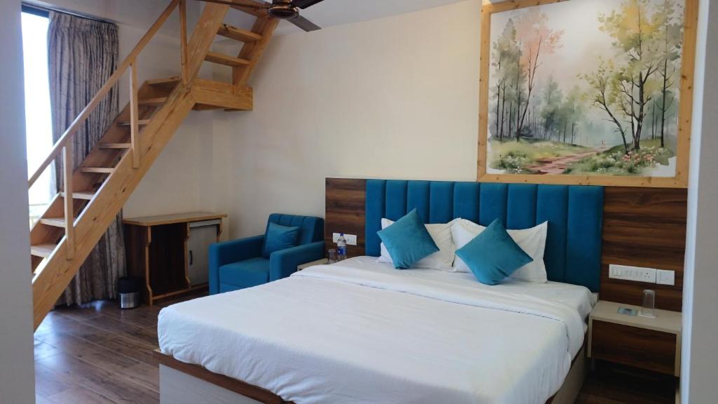 a bedroom with a bed with a blue headboard and a staircase at Hillshades Comfy rooms in Dagshai