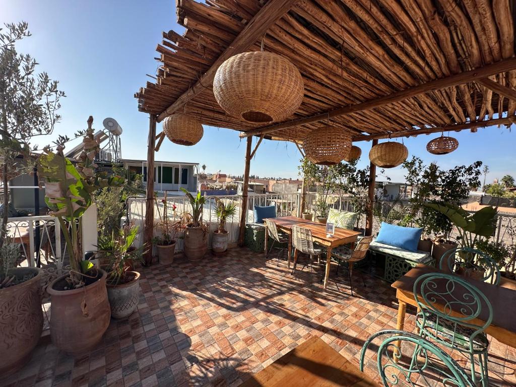 un patio avec une table, des chaises et des plantes en pot dans l'établissement Riad Green Vines, à Marrakech