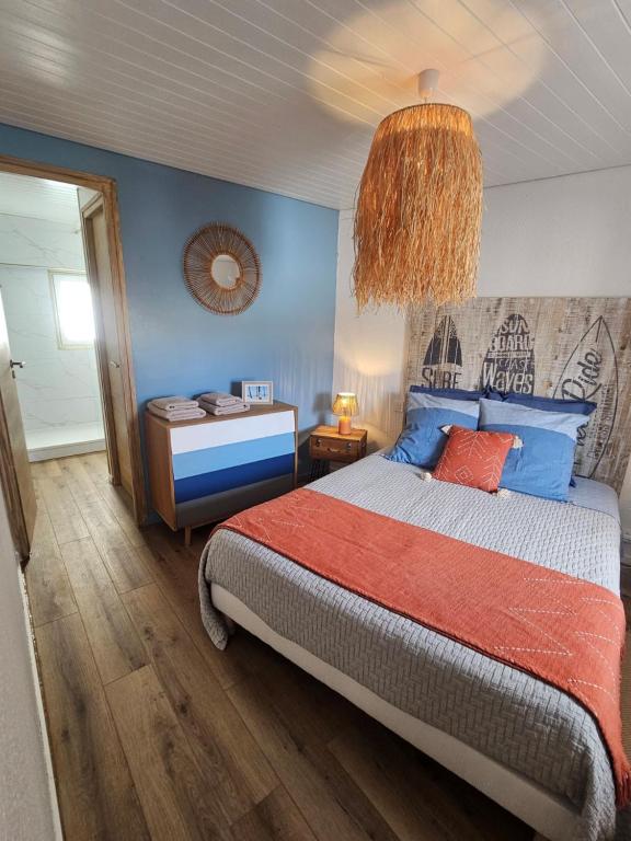 a bedroom with a bed and a chandelier at Gîte "Hawaï", avec parking securisé in La Roche-sur-Yon