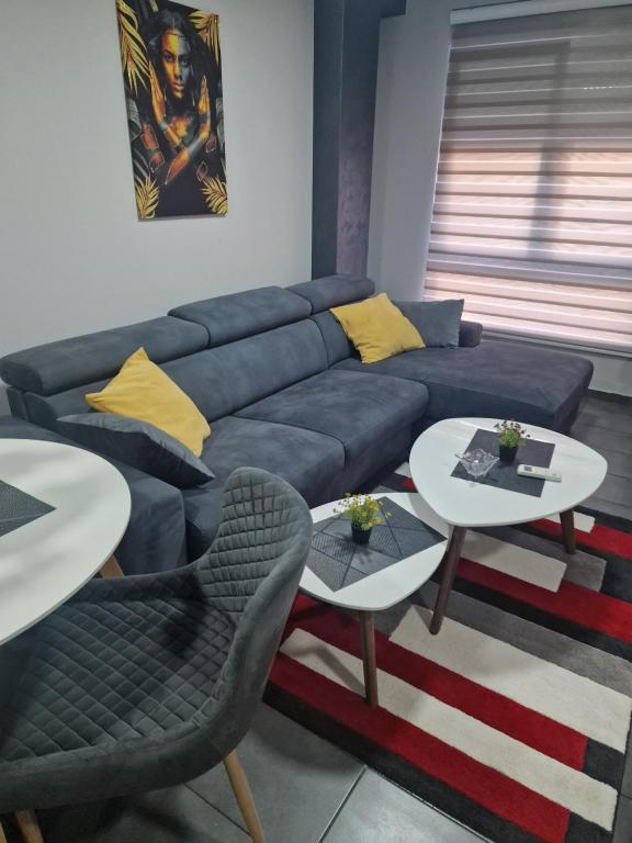 a living room with a blue couch and two tables at Silver city studio in Jagodina