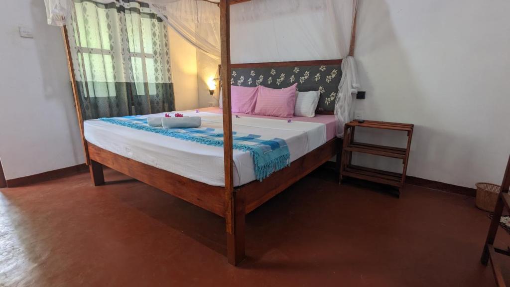 une chambre avec un lit à baldaquin dans l'établissement Rekawa Edge villa, à Netolpitiya