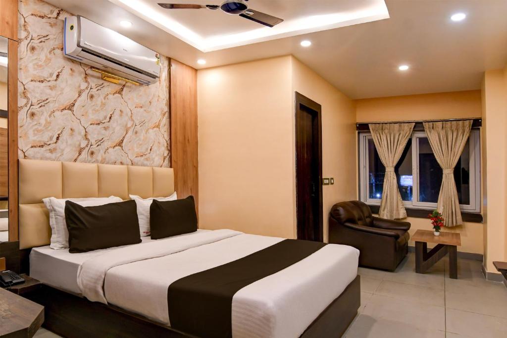 a hotel room with a bed and a chair at Super Townhouse OAK Bulbuli Neer in Kolkata