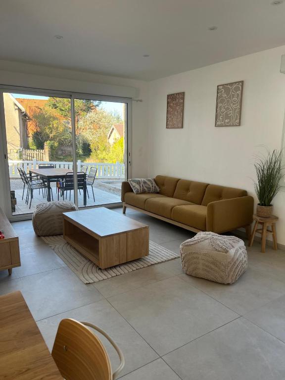 a living room with a couch and a table at Maison proche plage avec parking in Wimereux