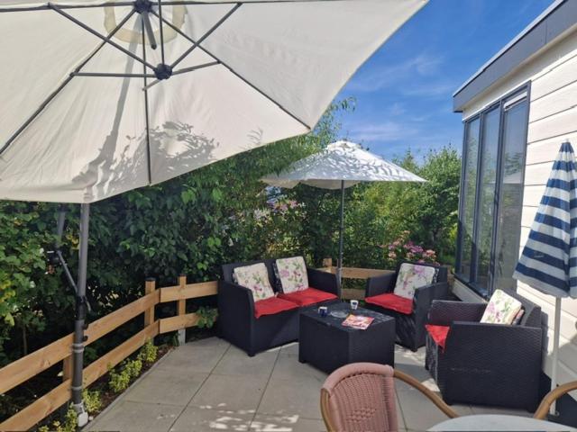 a patio with chairs and a table and an umbrella at Zeester in Ameland