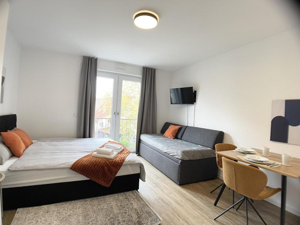 a bedroom with a bed and a couch and a table at Design Vogue Apartment-Zentral-WiFi-4Personen in Metzingen