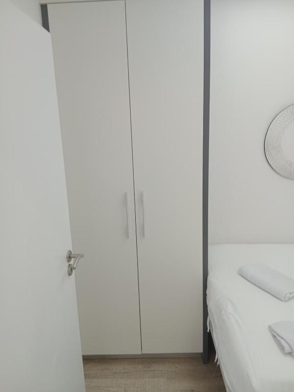 a bedroom with white cabinets and a bed at 1 on albert Luxury apartment in Cape Town