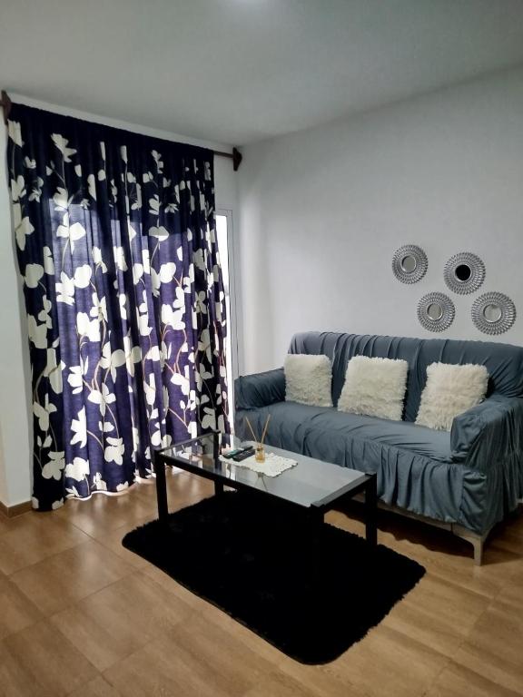 波萨达斯EDIFICIO REY NIÑO的客厅里有一张沙发和一张桌子。