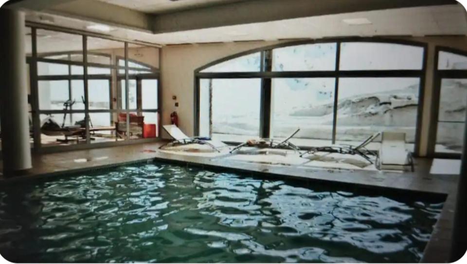 een groot zwembad met twee wastafels en ramen bij Hourquette in Bagnères-de-Bigorre