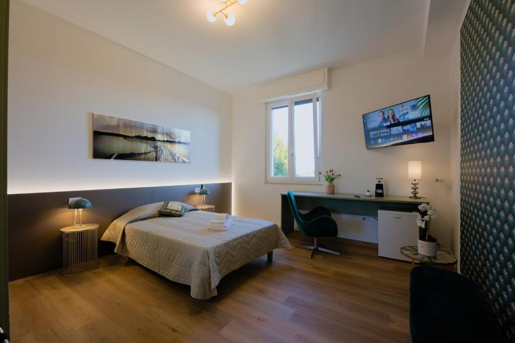 a bedroom with a bed and a desk in it at Camera Denver - La Casa di Carta Affittacamere in Udine