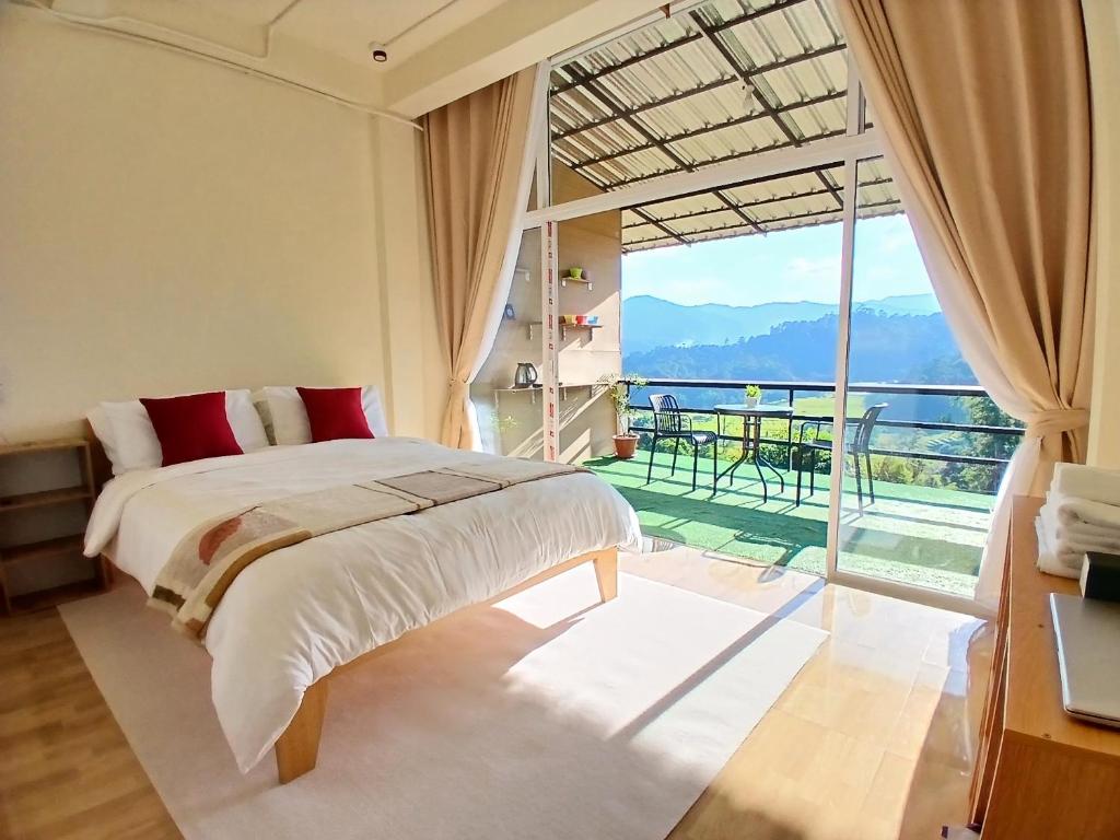 a bedroom with a bed and a large window at ดิ เอสเคป อินทนนท์ - The Escape Inthanon in Ban Yang