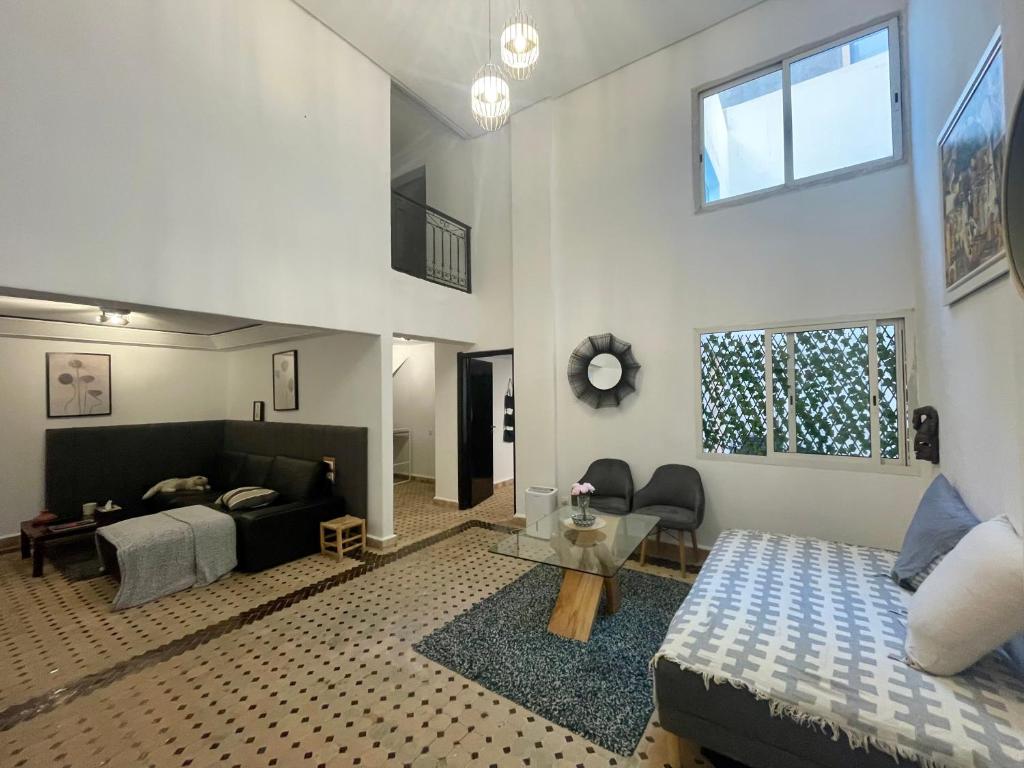 una camera da letto con un letto e un soggiorno di Au Riad Des Sultans - Marrakech a Marrakech