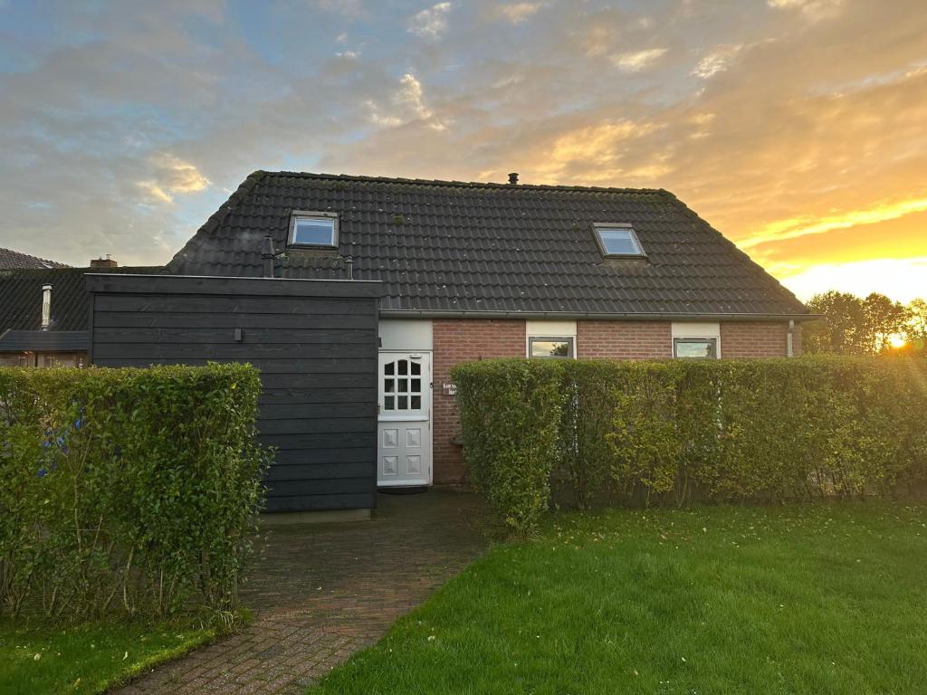 a house with a black roof and a white door at Landelijk Hijken in Hijken
