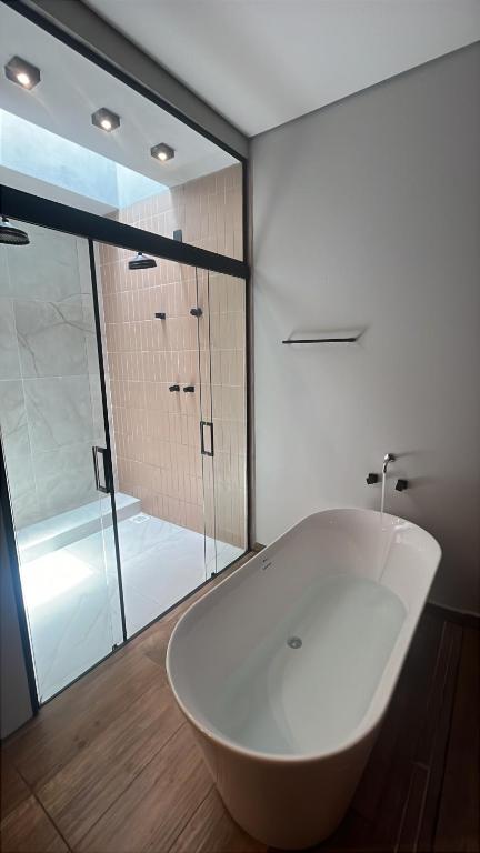 a white bath tub in a bathroom with a shower at Pousada Grão & Vinha in Espirito Santo Do Pinhal