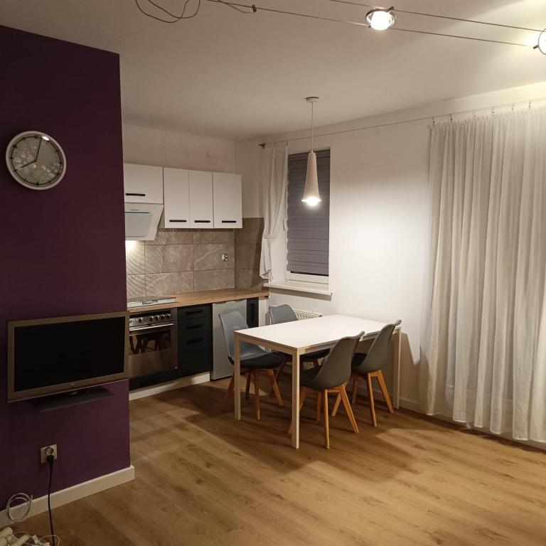 a kitchen with a table and chairs in a room at Apartament Jana in Warsaw