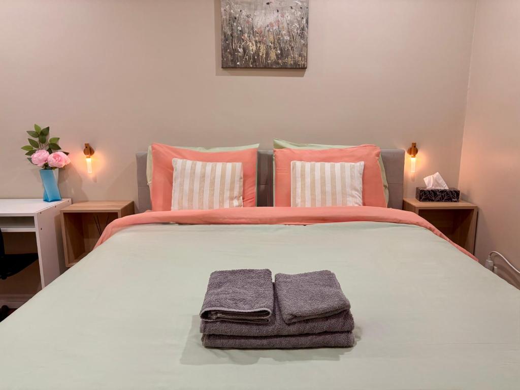 a bedroom with a bed with two towels on it at Vita House near Downsview and Yorkdale Shopping Center in Toronto