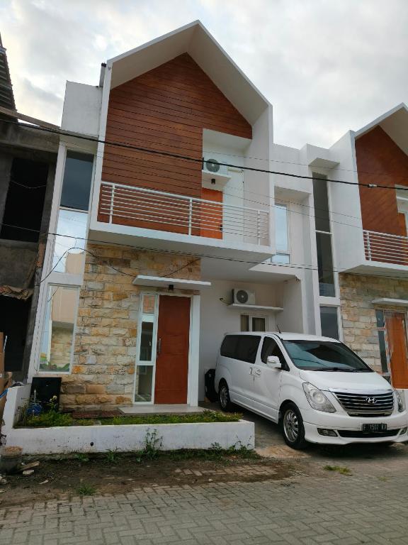 ein weißer Van vor einem Haus geparkt in der Unterkunft Villa Dino Park Batu in Karangploso