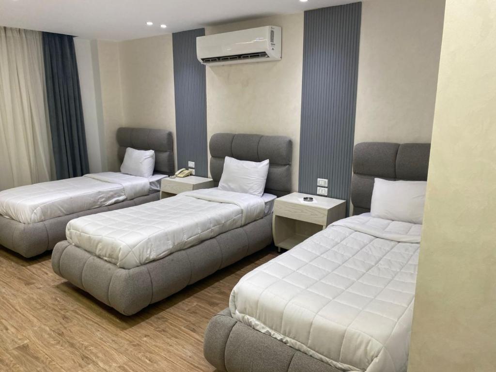 a hotel room with two beds and a couch at pyramids heaven inn in Giza